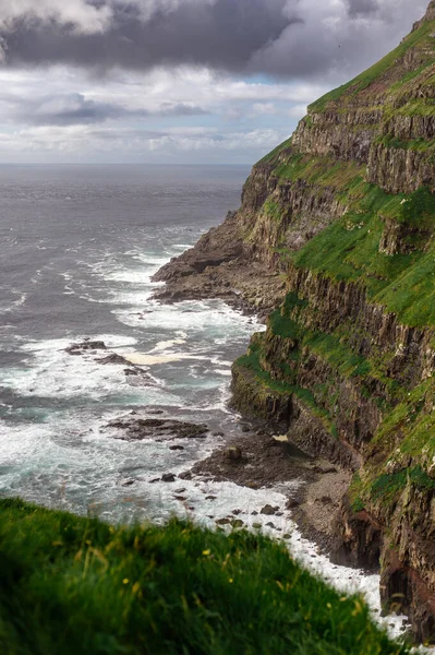Dramatik Mulafossur şelalesi Gasadalur köyü ve arka planda kayalıklarla okyanusa dökülüyor..