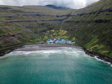 Streymoy 'un kuzey kıyısında etkileyici bir köy olan Tjornuvik' in manzarası dramatik dağlar ve okyanuslarla çevrili..