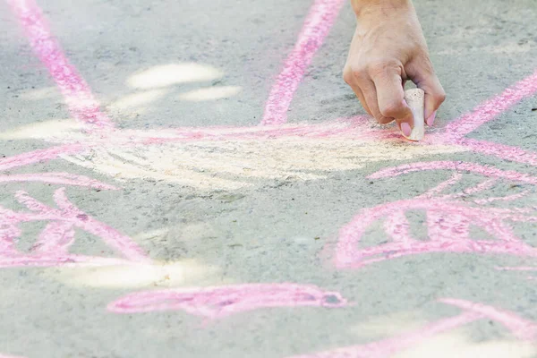 Kız yolda boya kalemleriyle resim çiziyor..