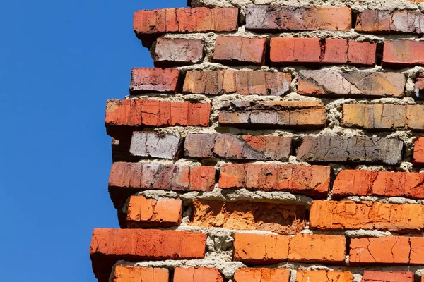 stock image Red old brick wall against a blue sky