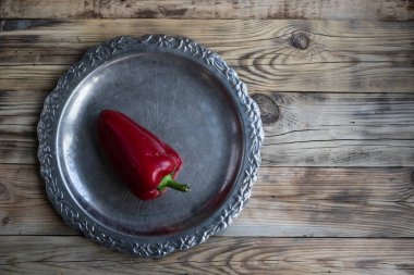 Ahşap arka plandaki tepside kırmızı biber ve boşluğun bir kopyası.