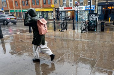 Londra mı? UK- Eylül 03. 2025 yılı. Sokakta bir yaya aniden yaz yağmuruna yakalandı..