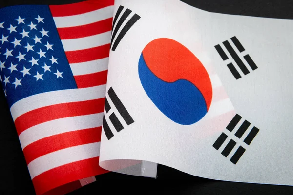 ABD ulusal bayrağı ve Güney Kore bayrağı siyah üzerine izole edildi. Bir ABD, Güney Kore ilişkileri kavramı.