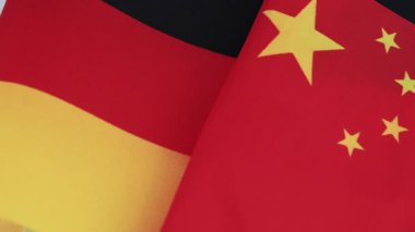 Alman ulusal bayrağının Çin ulusal bayrağının yanına yakın plan. Bir Almanya-Çin ilişkileri kavramı.