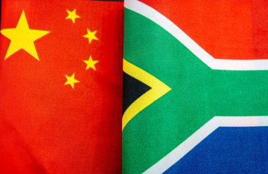Güney Afrika bayrağının yanında Çin ulusal bayrağının yakın çekimi. Çin ve Güney Afrika ilişkileri kavramı.