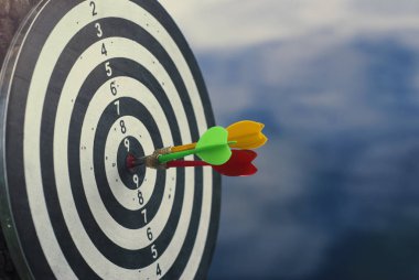 Dart tahtası merkezinde üç dart oku vurdu. Hedef başarı ve kazanan kavramı.