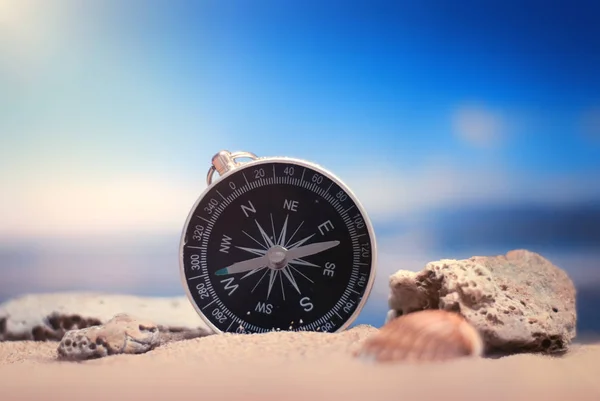 Time to Travel. Idea for tourism with compass on the sand with corals on the background of the sea