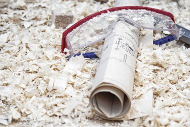 Koruyucu gözlük bir yapısı ile talaş arka plan üzerinde planlayın. Konsept inşaat ve onarım bir konu.