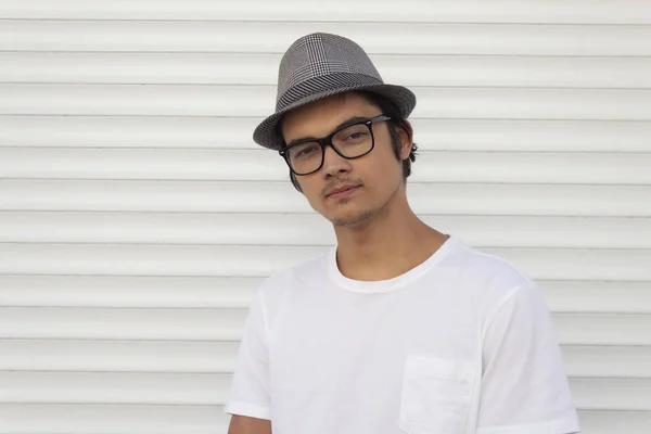 Retrato de um jovem em um chapéu e óculos, em um fundo branco . — Fotografia de Stock