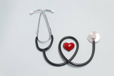 Kavram Sağlık konu üzerinde. Açık mavi arka planda kırmızı kalp ile stetoskop.