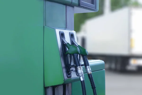 Primer plano de la gasolinera con mangueras de combustible de color de fondo en la carretera y el coche . — Foto de Stock