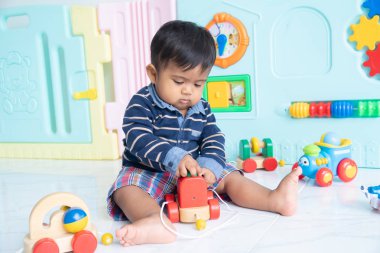 Şirin mutlu küçük Asya çocuk yalan ahşap oyuncak araba oyna