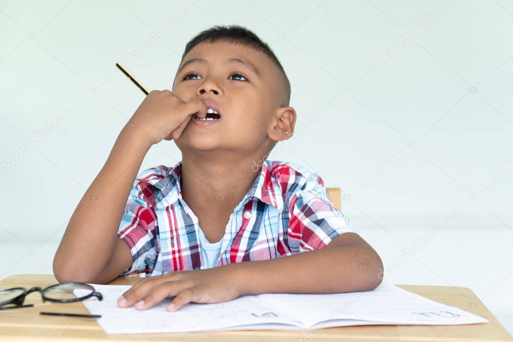 Cute asian little boy write homework 
