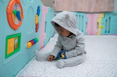 Sevimli küçük asin bebek çocuk oturma ve oyun oyuncak içinde Oda