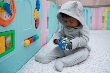 Sevimli küçük asin bebek çocuk oturma ve oyun oyuncak içinde Oda