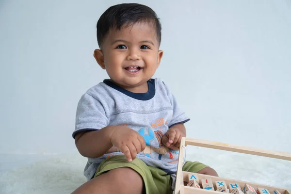 Lindo pequeño asin bebé niño jugando con madera juguete —  Fotos de Stock