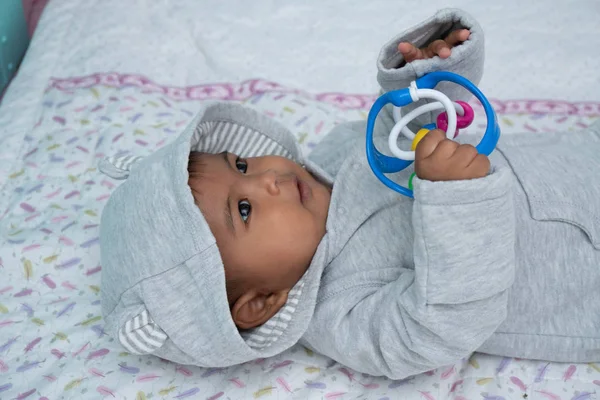 Lindo pequeño asin bebé niño acostado en suave manta y jugar juguete — Foto de Stock