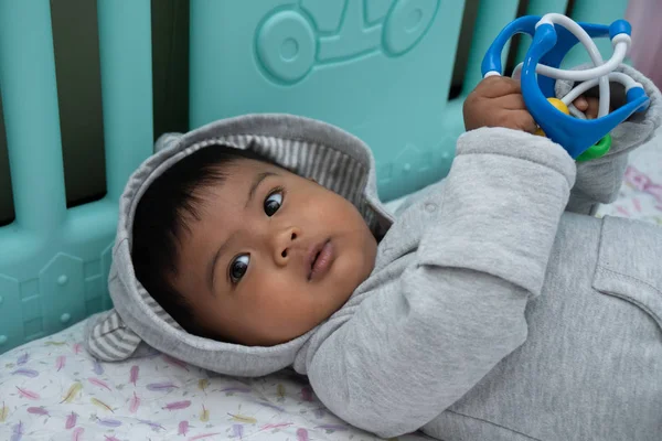 Lindo pequeño asin bebé niño acostado en suave manta y jugar juguete — Foto de Stock