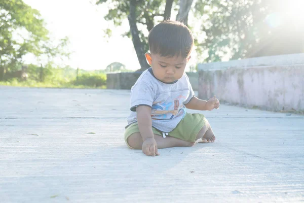 Menino pequeno jogar pau madeira no parque — Fotografia de Stock