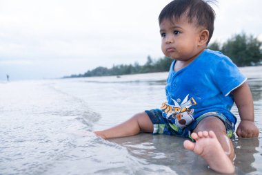 sahilde sevimli küçük erkek bebek oyun