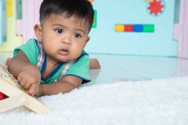 ittle bebek erkek yalan ve ahşap oyuncak oynamak