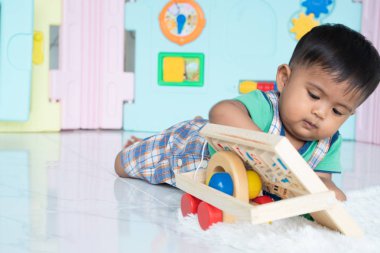 ittle bebek erkek yalan ve ahşap oyuncak oynamak