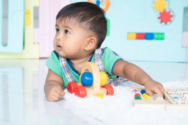 ittle bebek erkek yalan ve ahşap oyuncak oynamak