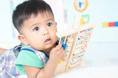 ittle bebek erkek yalan ve ahşap oyuncak oynamak