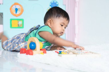 ittle bebek erkek yalan ve ahşap oyuncak oynamak