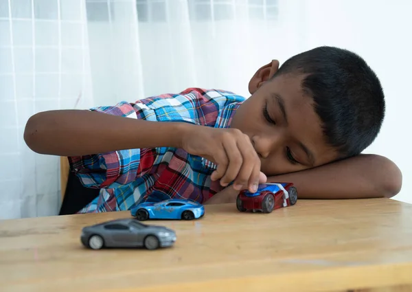 Грустный Мальчик Лежит Столе Играет Игрушечную Машину — стоковое фото