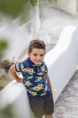 Portre sevimli küçük bir çocuk karşı bir taş duvar