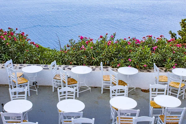 Tables and chairs near the sea in a restaurant.