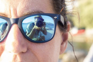 Bir kadının bardaklarda fotoğrafçı yansıması