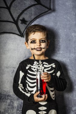 Küçük çocuk Cadılar Bayramı'nda sahte kan içme bir iskelet kostüm
