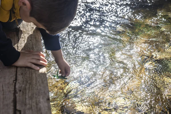 Kind Zet Een Boot Gemaakt Van Planten Het Water — Stockfoto