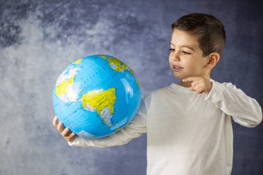 Küçük çocuk bir dünya top ile gülümseyen