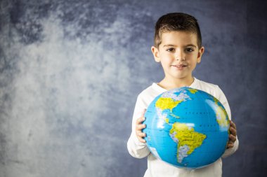 Küçük çocuk bir dünya top ile gülümseyen