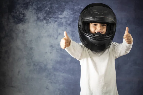 Bir motosiklet kask ile oynayan küçük çocuk