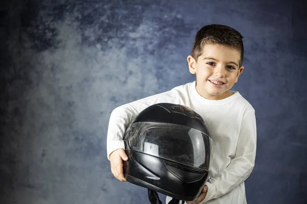 Bir motosiklet kask ile oynayan küçük çocuk