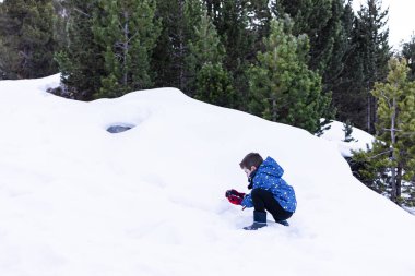 Bir kış günü kar ile oynayan çocuk