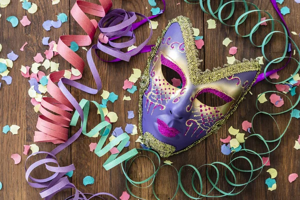 Ahşap arka plan konfeti ile karnaval maskesi