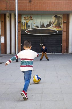 Sokakta futbol oynayan iki çocuklar