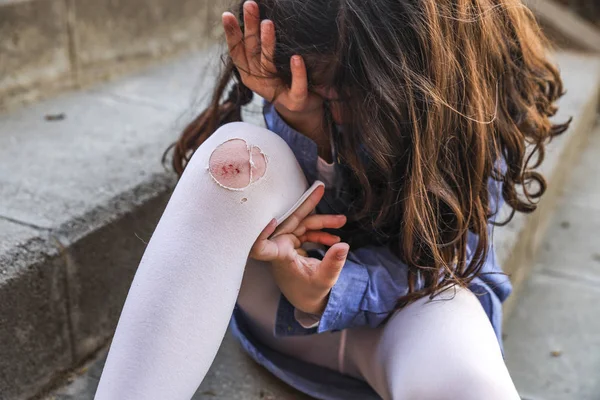 Little girl crying with a wound on her knee — Stock Photo, Image