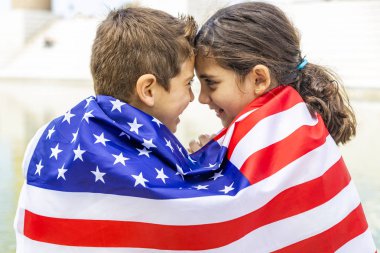 Amerikan bayrağına sarılı iki çocuk
