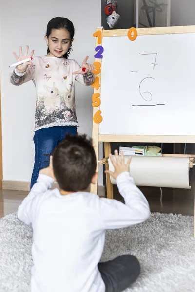 Två barn leker med en vit bräda — Stockfoto