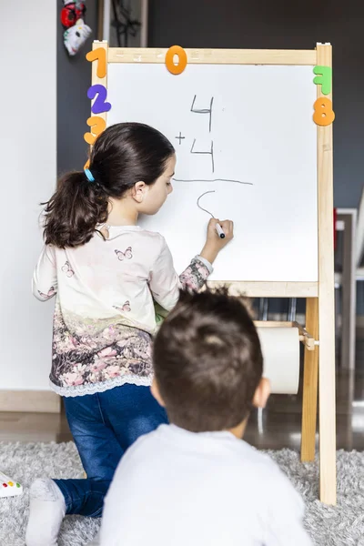 Dos niños jugando con un tablero blanco — Foto de Stock