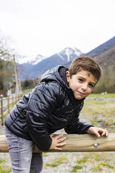 Retrato de um menino bonito em uma cerca de campo — Fotografia de Stock