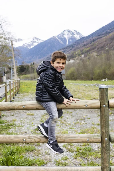 Retrato de um menino bonito em uma cerca de campo — Fotografia de Stock