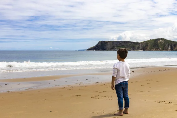 Одинокий мальчик на пляже смотрит на зайца — стоковое фото