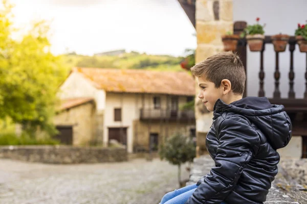 Carino ragazzo seduto su un bellissimo villaggio — Foto Stock
